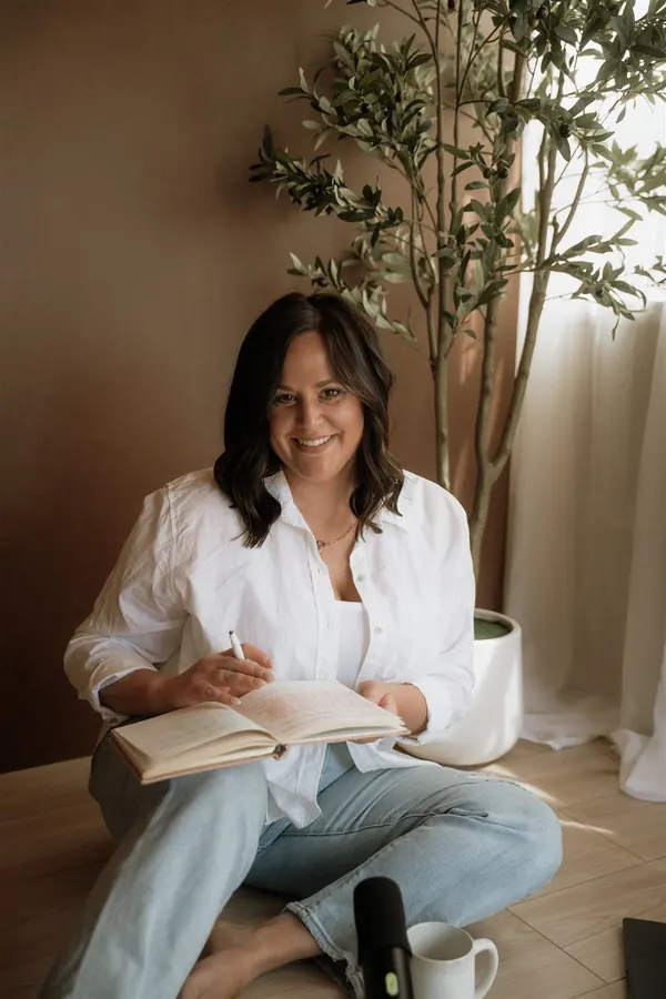 Cydnie Jocelyn sitting with an open notebook on her lap, writing.