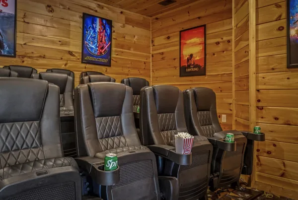 A row of reclining cinema seats under film posters.