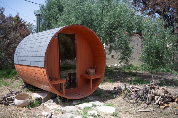 A barrel sauna standing in the olive grove in the grounds.