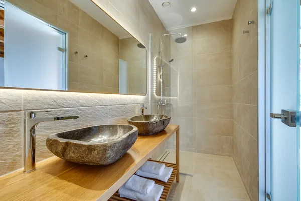 An en-suite bathroom at Armonia with a carved stone basin on a timber counter.