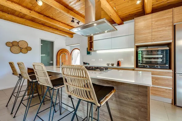 The kitchen at Armonia, a run of timber and stone with stools along the counter.