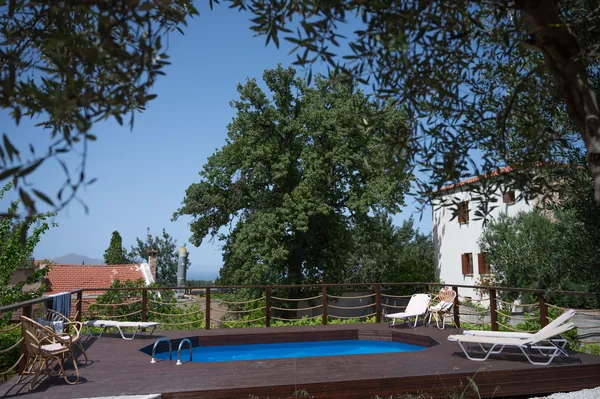 The pool deck at Armonia in the late afternoon, the valley and the hills beyond the fence.