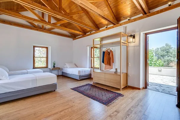 A guest room at Armonia: two single beds, a wooden floor, an open door to the terrace.