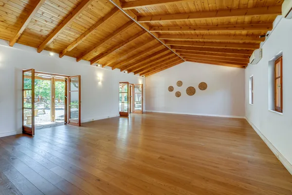 The indoor studio at Armonia: a bare wooden floor, white walls and a beamed ceiling.