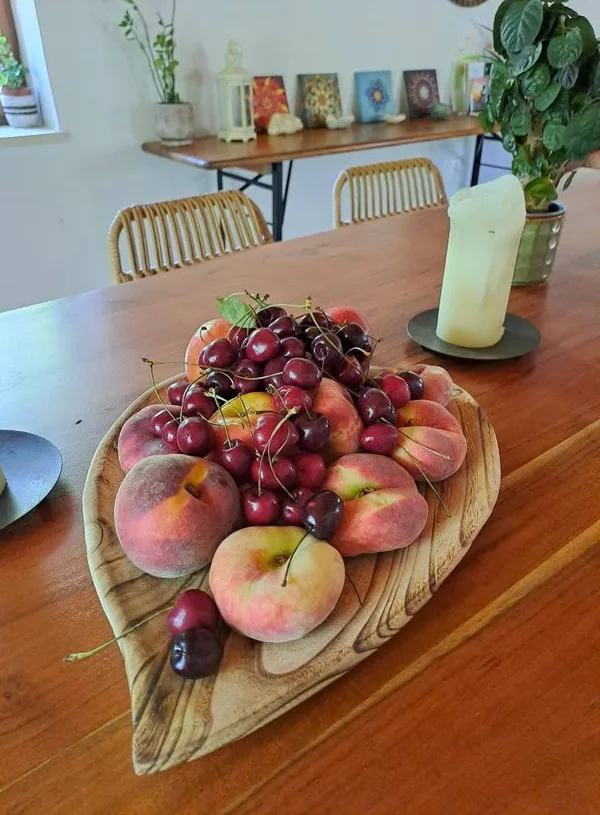 A bowl of peaches, plums and grapes on the wooden dining table at Armonia.