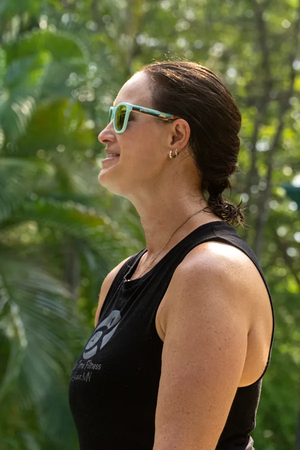 Kris Krause outdoors in a Your Time Fitness vest, looking off to one side.