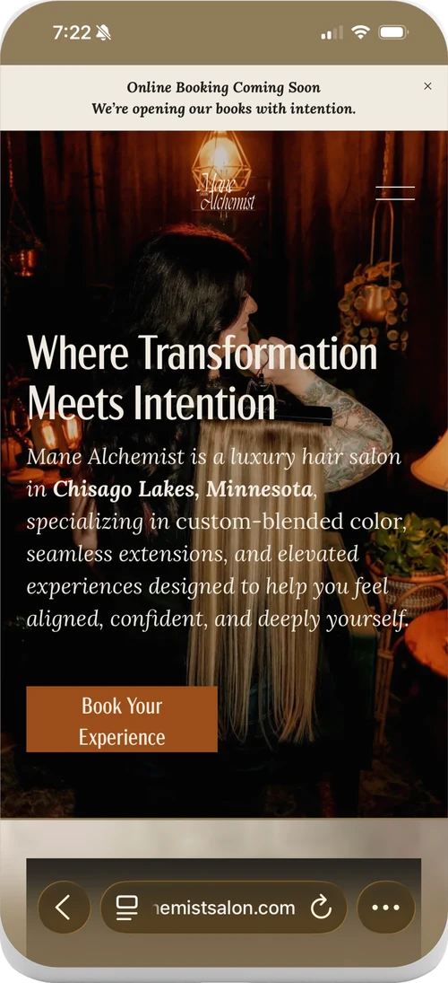 The Mane Alchemist home page on a phone, headed Where Transformation Meets Intention over a warm, low lit salon photograph.